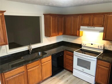 Kitchen featuring range hood, black dishwasher, white range with electric cooktop, a sink, and light wood-type flooring