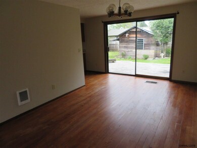 Generous room with wood flooring & slider to rear 