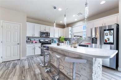 Kitchen with decorative light fixtures, a breakfas