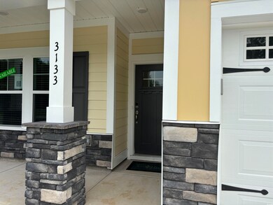 Property entrance featuring covered porch and ston