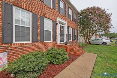 Property entrance with brick siding and a lawn