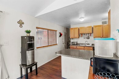 Kitchen with lofted ceiling, dark hardwood / wood-