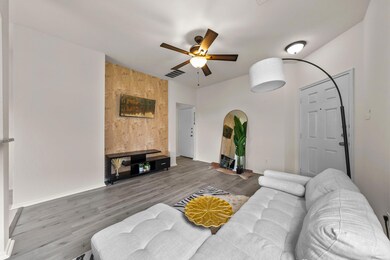 Living area with ceiling fan, arched walkways, an