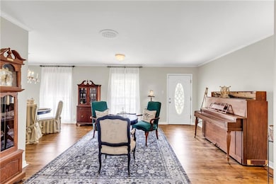 Dining area featuring wood finished floors, ornamental molding, and a chandelier