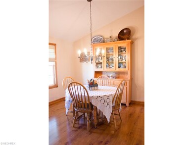 The dining room has laminate wood floor and vaulted ceiling.