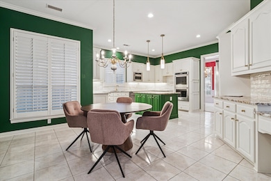 Dining space with a chandelier, light tile patterned floors, crown molding, and recessed lighting