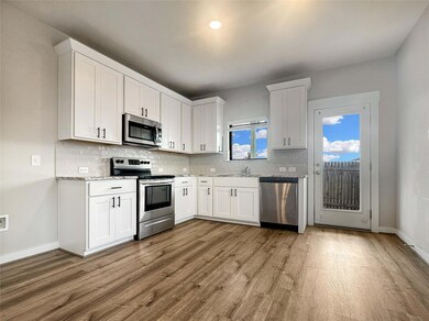 Kitchen with stainless steel appliances, wood fin