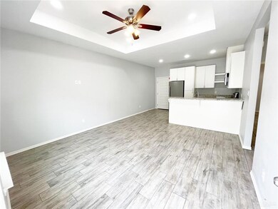 Open living room featuring light wood like tile floors- clean and move in ready plus recessed lighting.