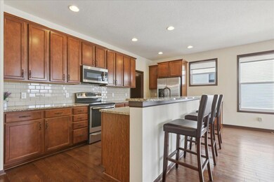 Kitchen features granite counters and custom backsplash