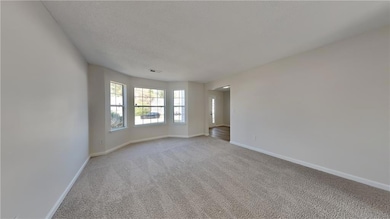 Unfurnished room with baseboards, carpet floors, and a textured ceiling