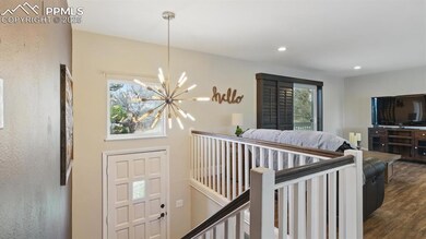 Front Entry with modern chandelier and stairs to the upper level.