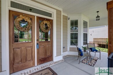 Covered front porch features bay windows, wood col