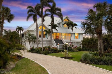 Raised beach house with stairway, driveway, a yard