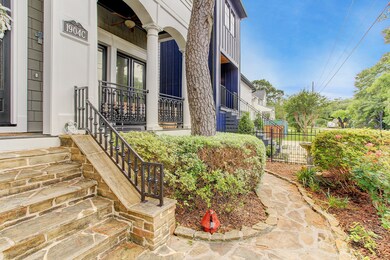 Welcoming Front Yard with stone pavers, custom stone work, and handsome iron work.