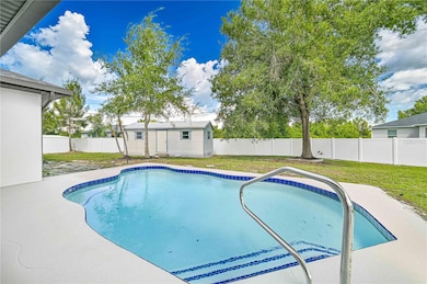 sparkling pool with fence in backyard and extra shed