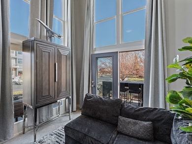 Living area featuring a towering ceiling and carpet flooring