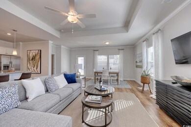 Living area with crown molding, baseboards, a rais
