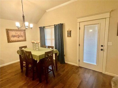 Dining space with vaulted ceiling, dark wood-type flooring, and an inviting chandelier