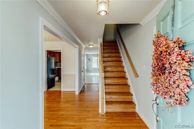 Foyer with hardwood floors, crown molding and hardwood staircase!