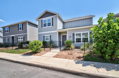 View of front of property with board and batten siding and a fenced front yard