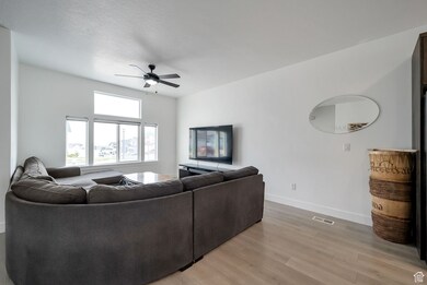 Living room with light wood finished floors and ceiling fan