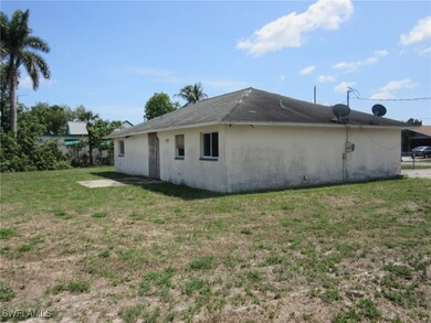 Rear view of property featuring a yard and stucco