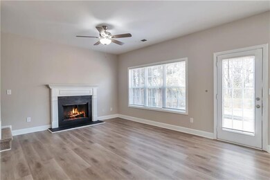 Unfurnished living room featuring baseboards, a he