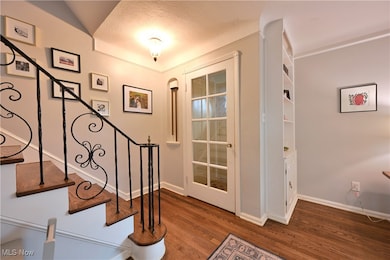 Stairs with wood finished floors and a textured ceiling