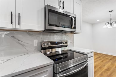 Kitchen featuring light wood-style flooring, stain