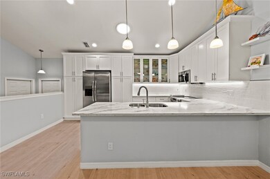 Kitchen featuring white cabinets, sink, light wood
