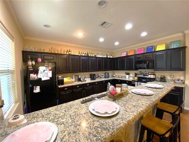 Kitchen with black appliances, a breakfast bar are