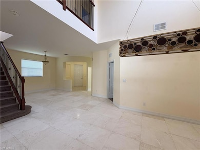 Unfurnished living room featuring a high ceiling and stairs