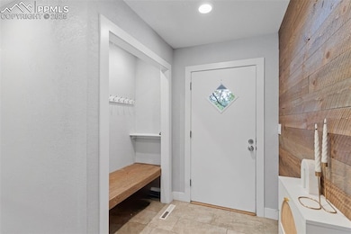 Mudroom entry with decorative woodwork and built-in bench