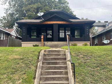 Bungalow with a porch, a front yard, and stairway