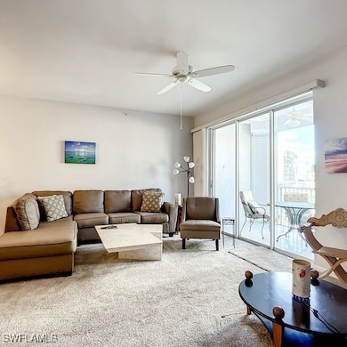 Living room featuring carpet and a ceiling fan