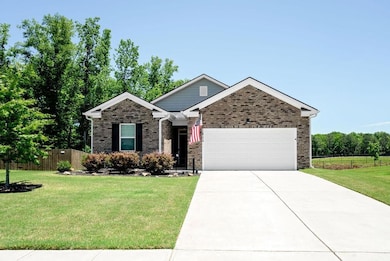 View of front of property featuring an attached garage, driveway, and brick siding