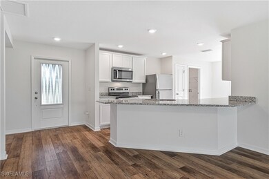 Kitchen with dark hardwood / wood-style flooring,