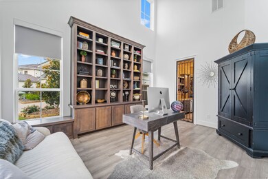 This large home office is perfect with it's high ceilings, abundance of sunlight, custom bookshelf with window seats, remote controlled shades and access to the wine room.