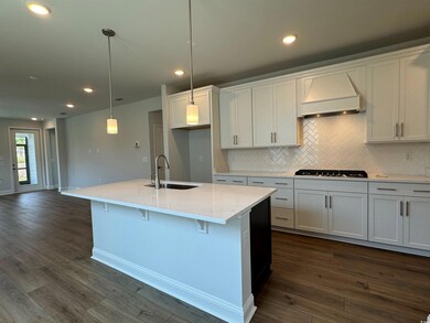 Kitchen featuring backsplash, sink, white cabinets