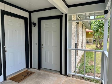 Doorway to property with stone siding and a porch