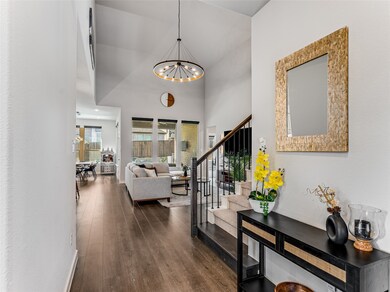 Hall with a high ceiling, dark wood-type flooring, stairway, and a chandelier