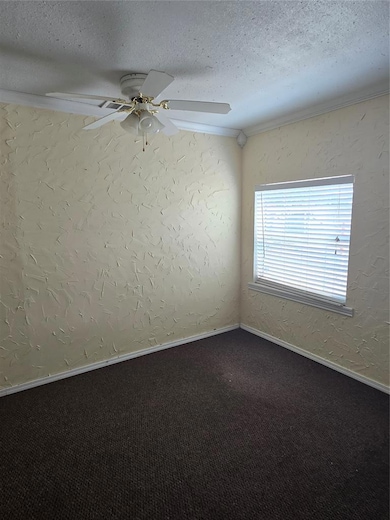 Spare room with a textured wall, crown molding, ceiling fan, a textured ceiling, and carpet