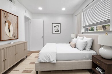 Bedroom with wood finished floors and recessed li