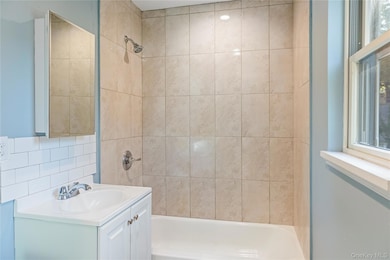 Bathroom with vanity, shower / tub combination, and tasteful backsplash