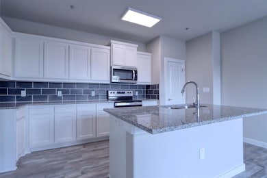 Kitchen featuring white cabinetry, appliances with