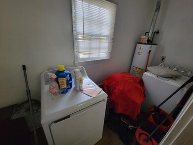 Laundry room with water heater and washing machine and dryer