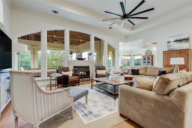 Living room featuring ceiling fan, a warm lit fir