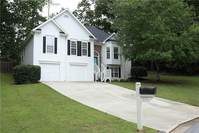 Split foyer home with driveway, an attached garage, and stairs