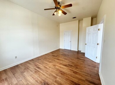 Unfurnished bedroom with wood finished floors, ba