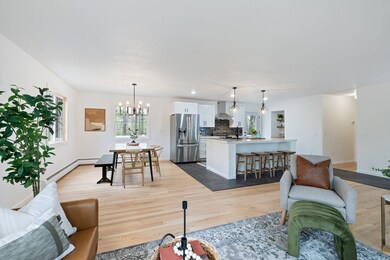 Living area featuring a baseboard heating unit, light wood-type flooring, a chandelier, and baseboards